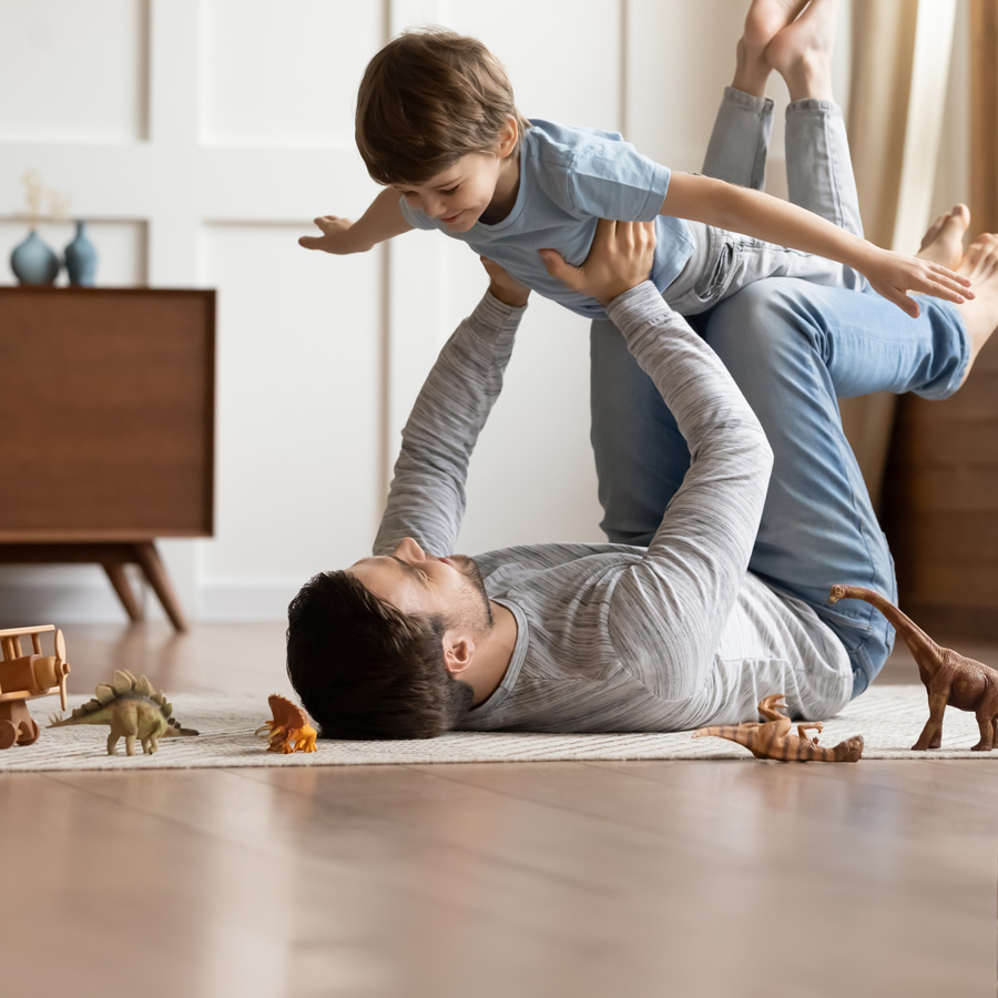 Father and son playing together on their living room floor.